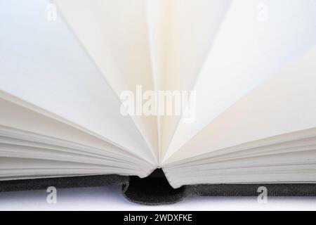 Open book with white blank open pages and a black linen cover, isolated on a white background Stock Photo