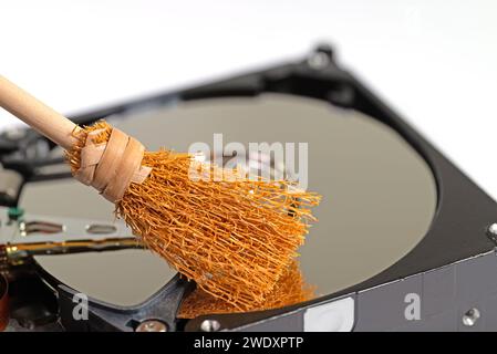 Broom on a hard drive, symbolic of disk cleanup Stock Photo