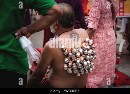 Georgetown, Penang, Malaysia - February 05, 2023: Hindu devotee with metal pots with offerings hooked on the back at Thaipusam festival Stock Photo