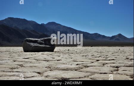 Isolated rock on desert floor Stock Photo