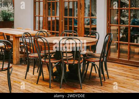 Round empty wooden table and chairs for meeting up in room, vintage style Stock Photo