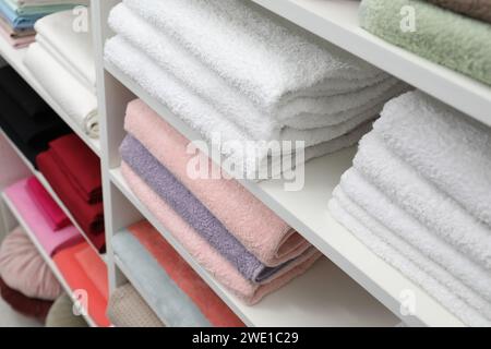 Bed linens and towels on shelves in shop Stock Photo