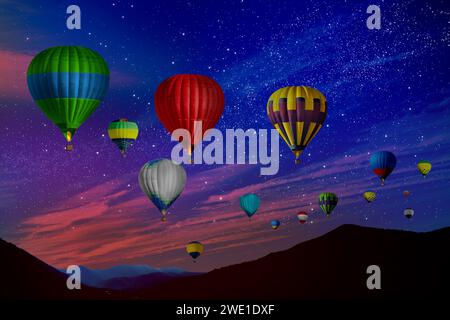 Bright hot air balloons flying in starry sky over mountain Stock Photo