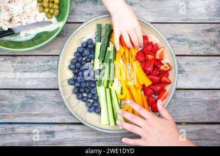 Healthy plate of fruits and vegetables on an outside table enjoying a summers evening. Stock Photo