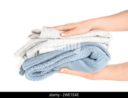 Female hands with stack of different stylish sweaters on white background Stock Photo