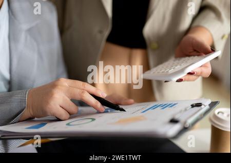 Two focused businesswomen or female accountants are brainstorming and working in the office together. businesspeople concept. close-up hand image Stock Photo