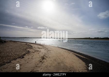 sandy beach with familys swimming at dusk on phillip island australia Stock Photo