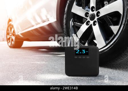 Air compressor. Car portable pump auto air compressor isolated. Car electric air compressor with manometer. Portable cordless tire inflator. Inflating Stock Photo