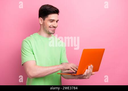 Photo of young man programmer web designer using netbook to create convenient interface for website isolated on pink color background Stock Photo