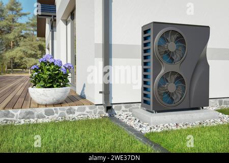 Double size black heat pump stays beside a wall of a cottage - 3d rendering Stock Photo