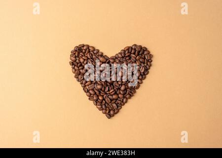 Heart made from coffee beans on beige background. Valentines day concept. Top view. Stock Photo