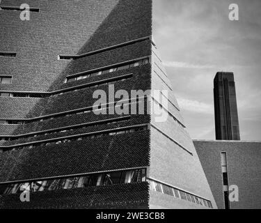 The new and old architecture of the Tate Modern with the large old chimney stack of the Turbine Hall including the new building extension. Stock Photo