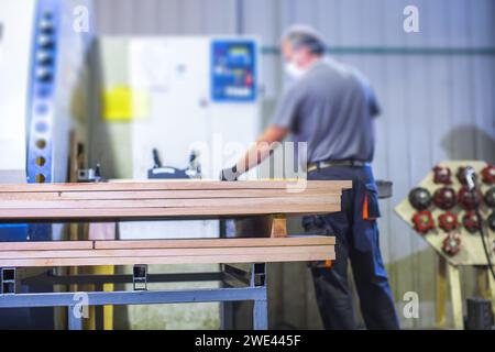 worker operating machine in wood processing facility Stock Photo