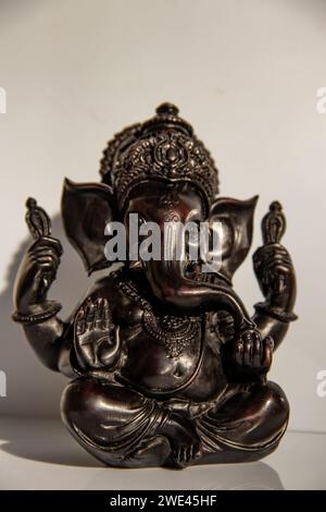 Black figurine of Lord Ganesh with white background Stock Photo