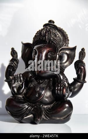 Black figurine of Lord Ganesh with white background Stock Photo