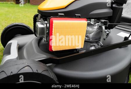 Air filter on gas powered lawn mower. Checking air cleaner filter for proper maintenance. Air filter on lawn mower tractor. Small engine repair, maint Stock Photo