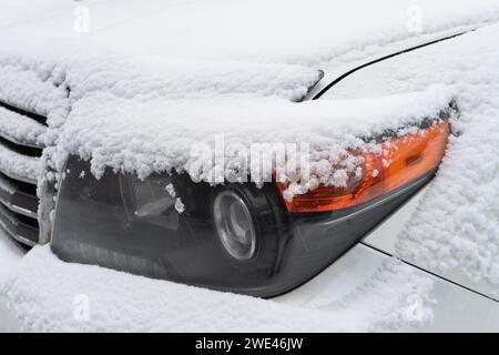 Frozen car. Car covered with snow and frost. Part of the car under snow after a heavy snowfall. The body of the car is covered with snow after blizzar Stock Photo