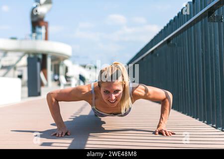 fit young woman doing pushups outdoors Stock Photo