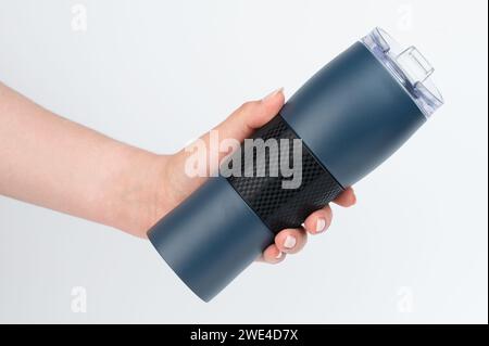 Metal blue mug in hand side view isolated on white studio background Stock Photo