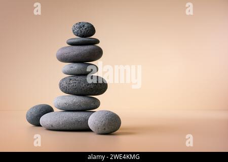Balancing pebble stones on beige background. Relax, meditation and zen concept. Stock Photo