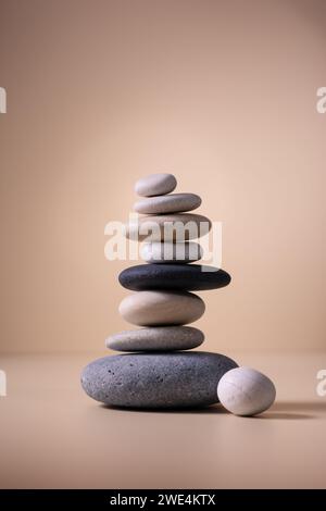 Balancing pebble stones on beige background. Relax, meditation and zen concept. Stock Photo