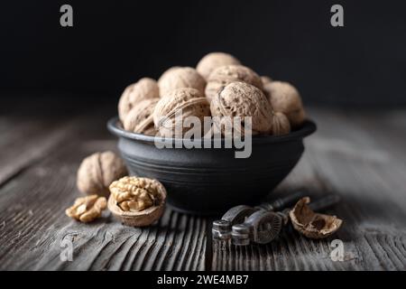 Walnut nuts with a vintage silver nut cracker on wooden table close up. Food photography Stock Photo