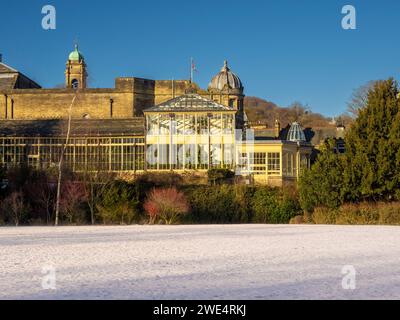 Exterior view of The Conservatory, with a light covering of snow on the ground. Pavilion Gardens, Buxton, Derbyshire, UK Stock Photo