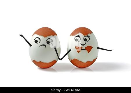 Two chicken eggs with shells and drawn faces and hands isolated on a white background. Comic decorated pair of eggs for a wedding in the form of a boy Stock Photo