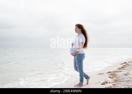 Pregnant woman enjoying the ocean. Pregnant woman on the beach. Happy healthy pregnancy.  wellness concept Stock Photo