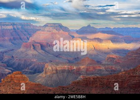 The last ray of sun broke through the clouds at sunset and illuminated the majestic Grand Canyon. Stock Photo