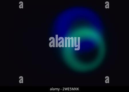 Elliptical shape of bright blue and cyan blurry lights with dark holes on a black backdrop Stock Photo