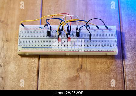 Breadboard with electrical elements, on a wooden table close up Stock Photo