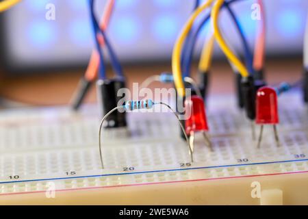 Breadboard with electrical elements, on a wooden table close up Stock Photo