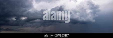 Dramatic sky background with dark rainy clouds before the storm. Panoramic view. Stock Photo