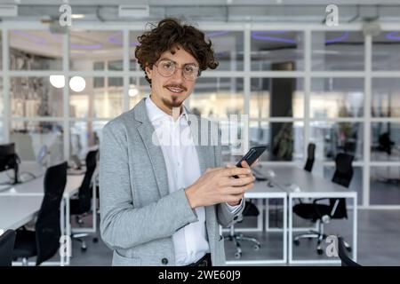 Expert young businessman with a pleasant demeanor working at his office, showcasing competence and dedication with a focused yet positive emotional state. Stock Photo