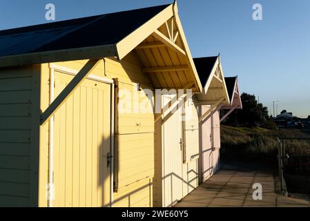 row of wooden beach huts brightly painted in pastel colors at the seaside Stock Photo