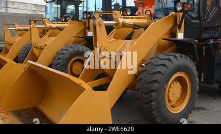 Close-up of yellow wheel loaders standing in a row Stock Photo