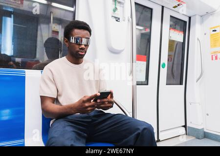 man with cyber glasses using smartphone sitting in metro Stock Photo