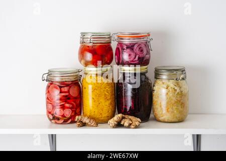 Jars with fermented vegetables on shelf at home Stock Photo