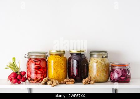 Homemade pickled vegetables in jars on shelf at home Stock Photo