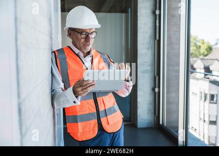 Engineer using tablet PC in corridor Stock Photo