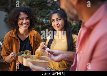 Happy people having fun eating together in garden Stock Photo