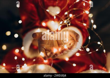 Girl holding string lights with cupped hands Stock Photo