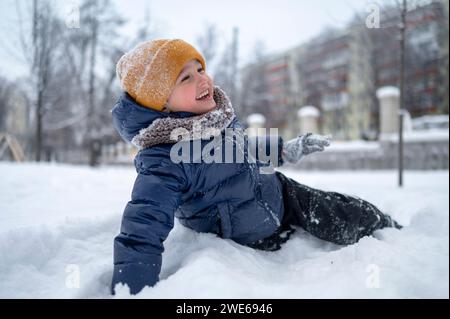 Happy boy enjoying in snow in park Stock Photo