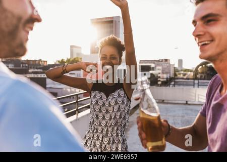 Carefree friends having party on rooftop Stock Photo