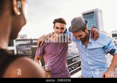 Smiling friends enjoying and spending leisure time on rooftop Stock Photo