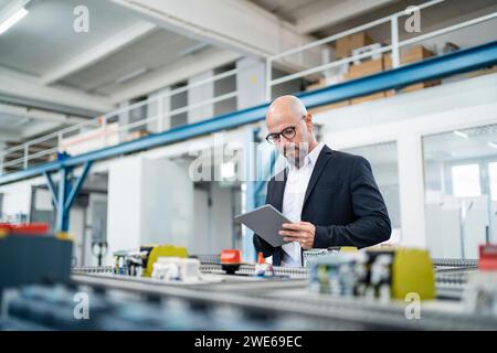 Engineer using tablet PC near machinery in factory Stock Photo