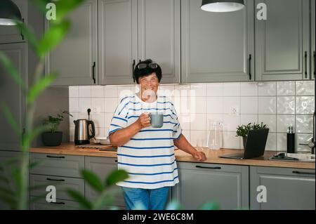 Smiling senior women having coffee in kitchen Stock Photo
