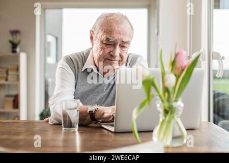 Senior man using laptop at home Stock Photo