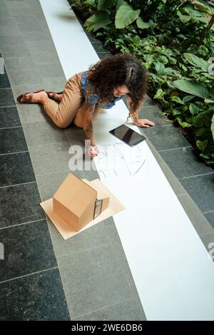 Young architect making plan and drawing on blueprint in office Stock Photo
